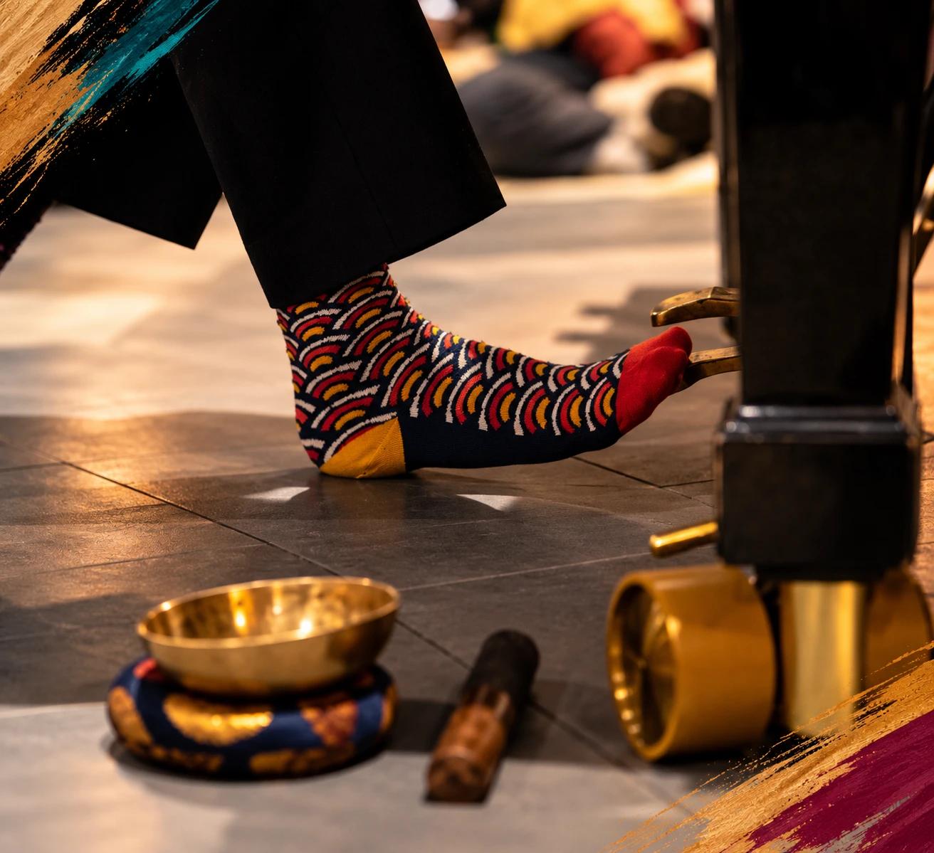Bunte Socken auf dem Boden neben dem Flügel, dazu eine Klangschale